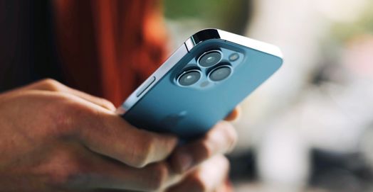 người đ&agrave;n &ocirc;ng đang g&otilde; tr&ecirc;n iPhone