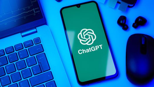 Logo ChatGPT tr&ecirc;n điện thoại th&ocirc;ng minh b&ecirc;n cạnh m&aacute;y t&iacute;nh x&aacute;ch tay
